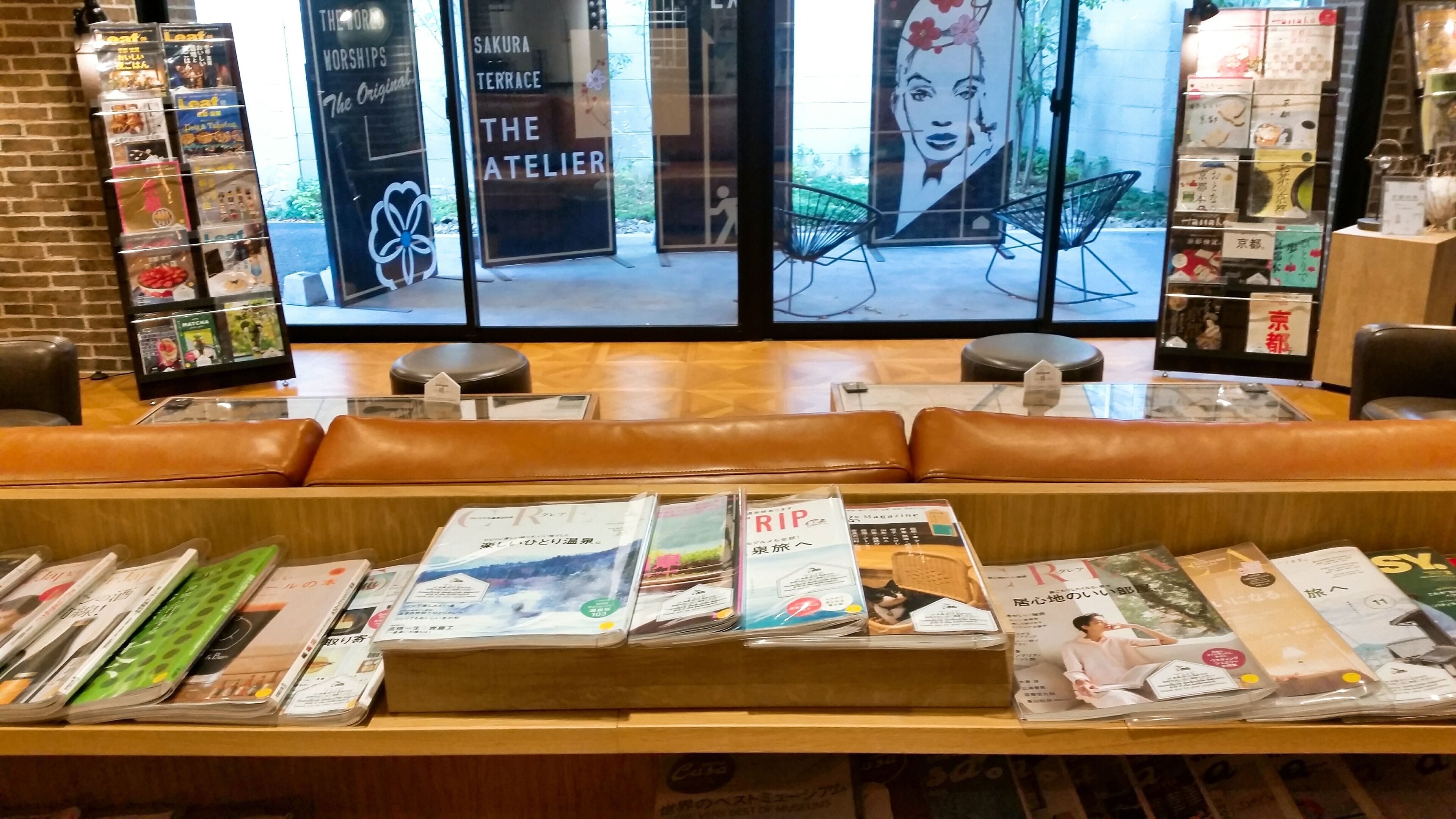 Een boekhandel met lederen zitplaatsen en een divers aanbod aan tijdschriften en boeken.