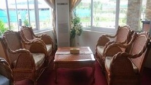 A room with wicker furniture, a red carpet, and large windows with a view of the outdoors. - Hsaung Thazin Hotel Nay Pyi Taw (Oattara Thiri Township)