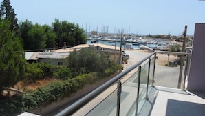Puerto deportivo con barcos amarrados, rodeado de vegetación y edificios.