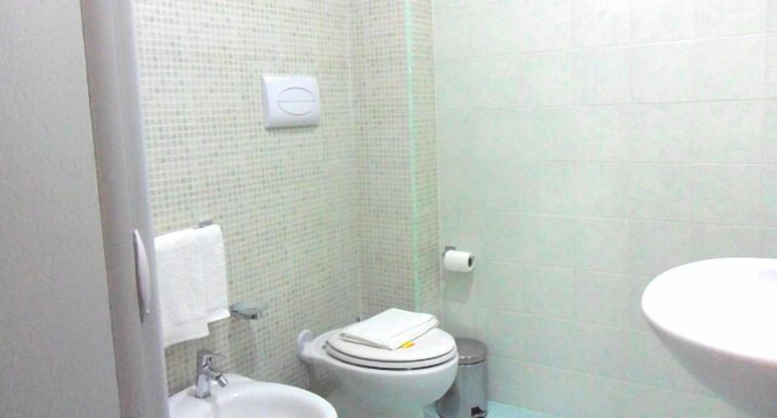Ein kleines Badezimmer mit Toilette, Bidet und Waschbecken.