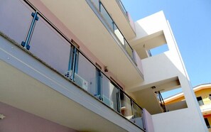 A multi-story building with balconies, large windows, and a clear sky. - Suliccenti (Pachino)