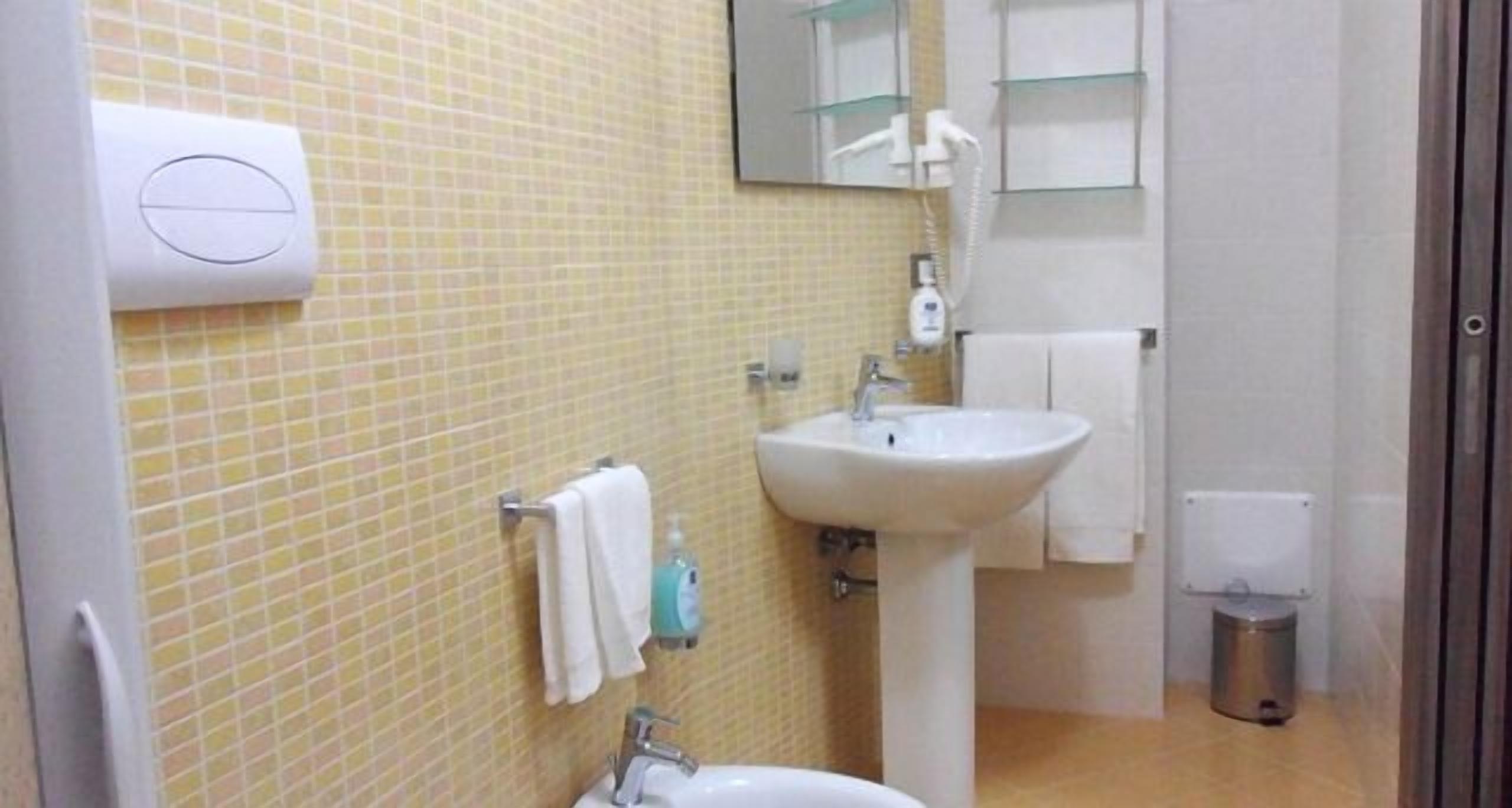 Un baño con lavabo, espejo y barra para toallas.