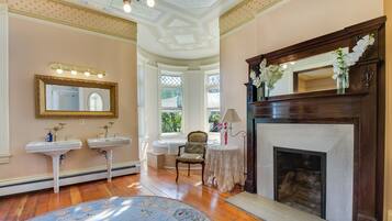 A room with two sinks, a fireplace, and a large mirror.