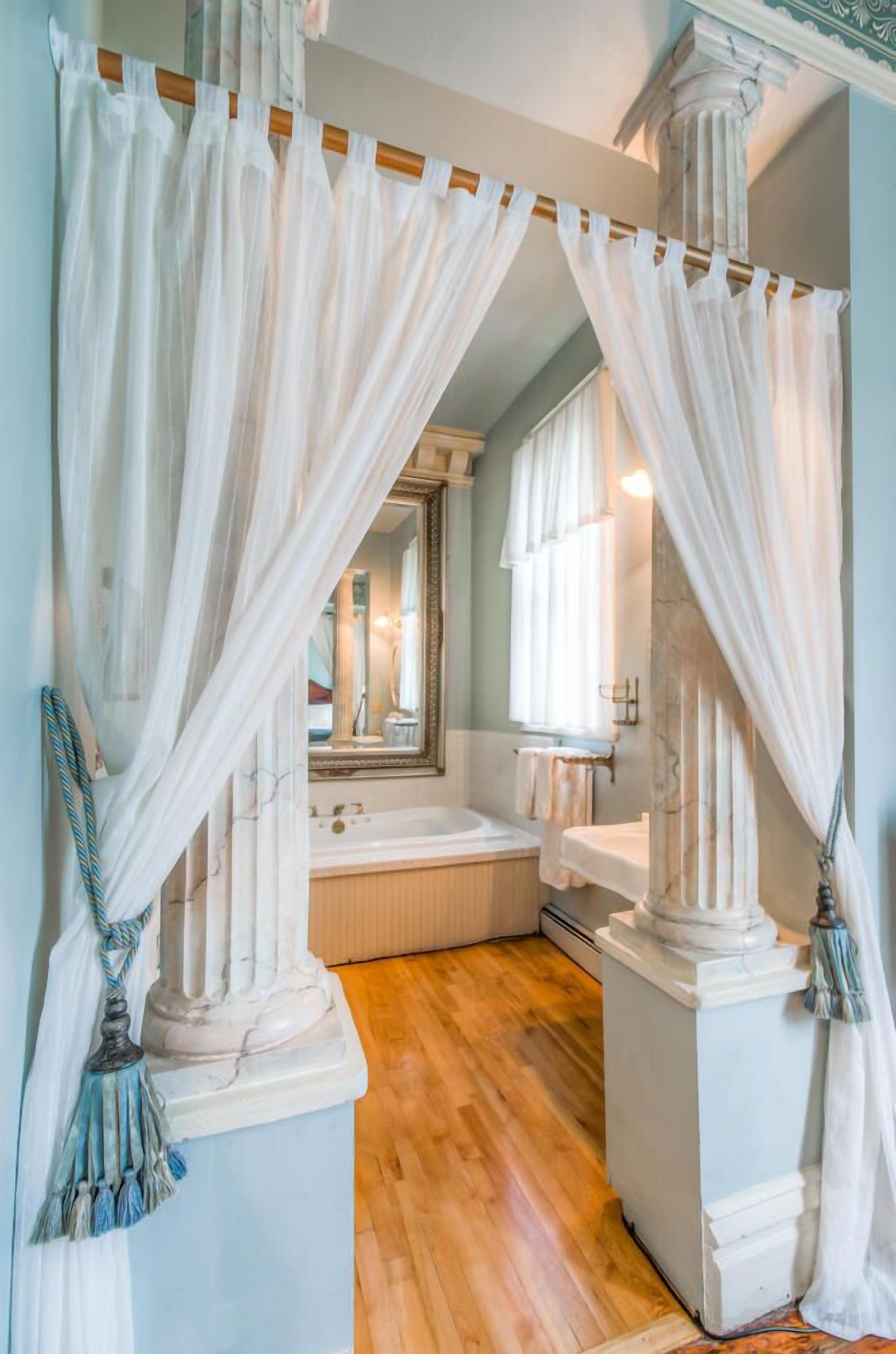 A bathroom with a bathtub, a mirror, and a vanity.