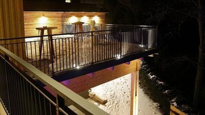 A wooden deck with a railing, a table, and chairs. - Der Klugbauer (Sankt Stefan ob Stainz)