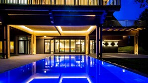 A modern building with a pool, large windows, and a covered patio area. - Der Klugbauer (Sankt Stefan ob Stainz)