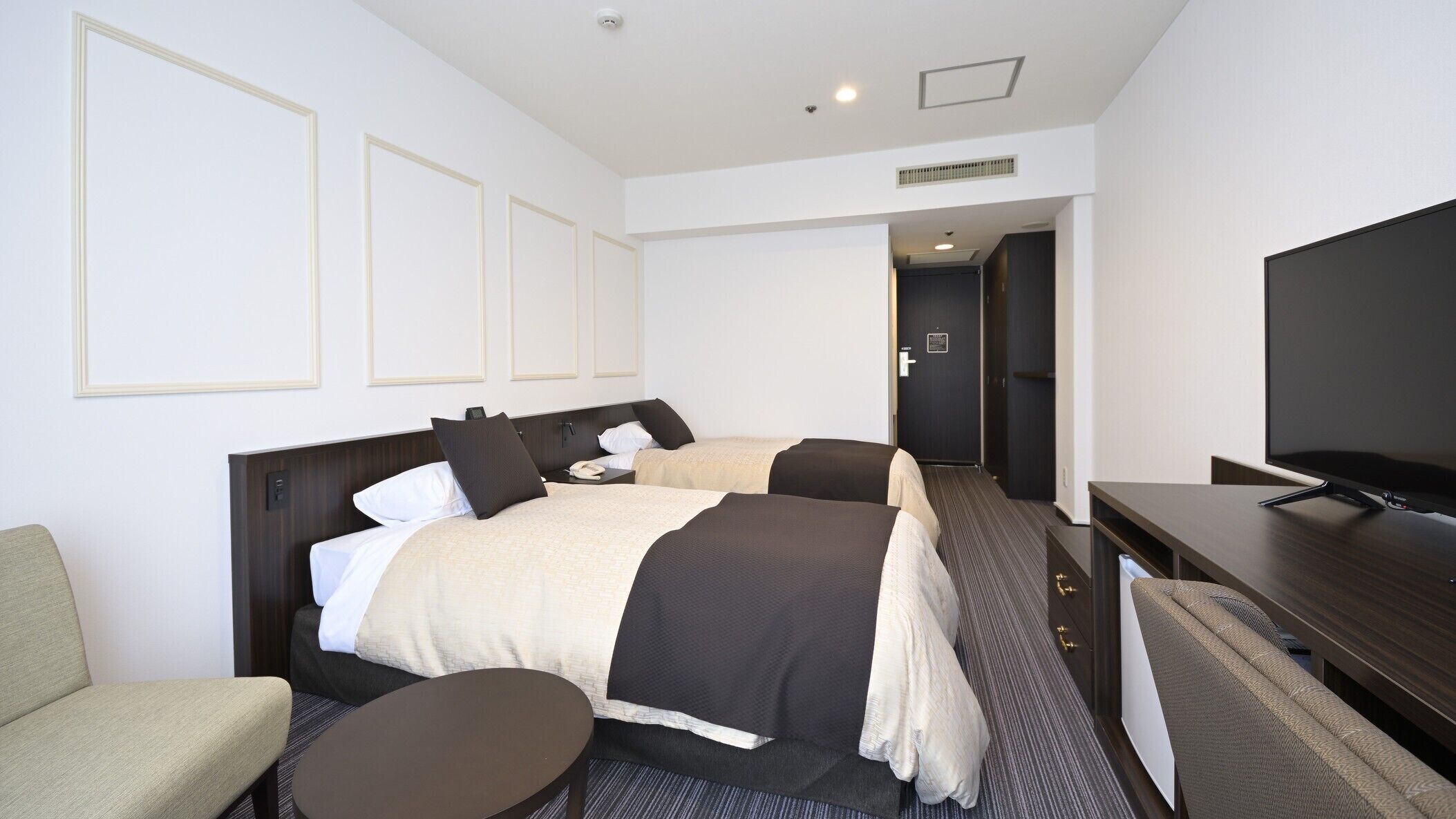 Une chambre d’hôtel avec un lit, une télévision, un bureau et une chaise.