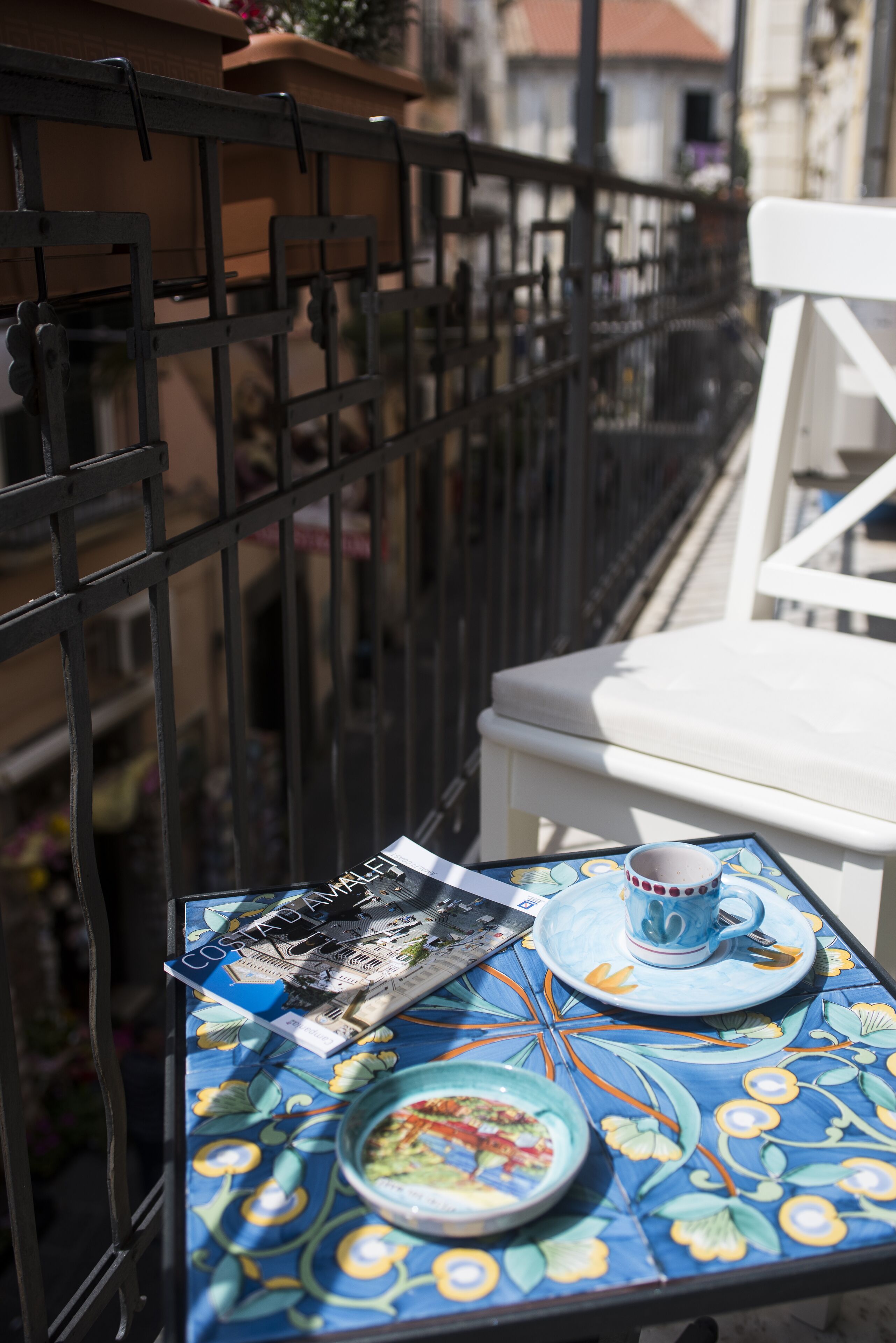 A table with a colorful tablecloth, a plate with food, a cup, and a menu.
