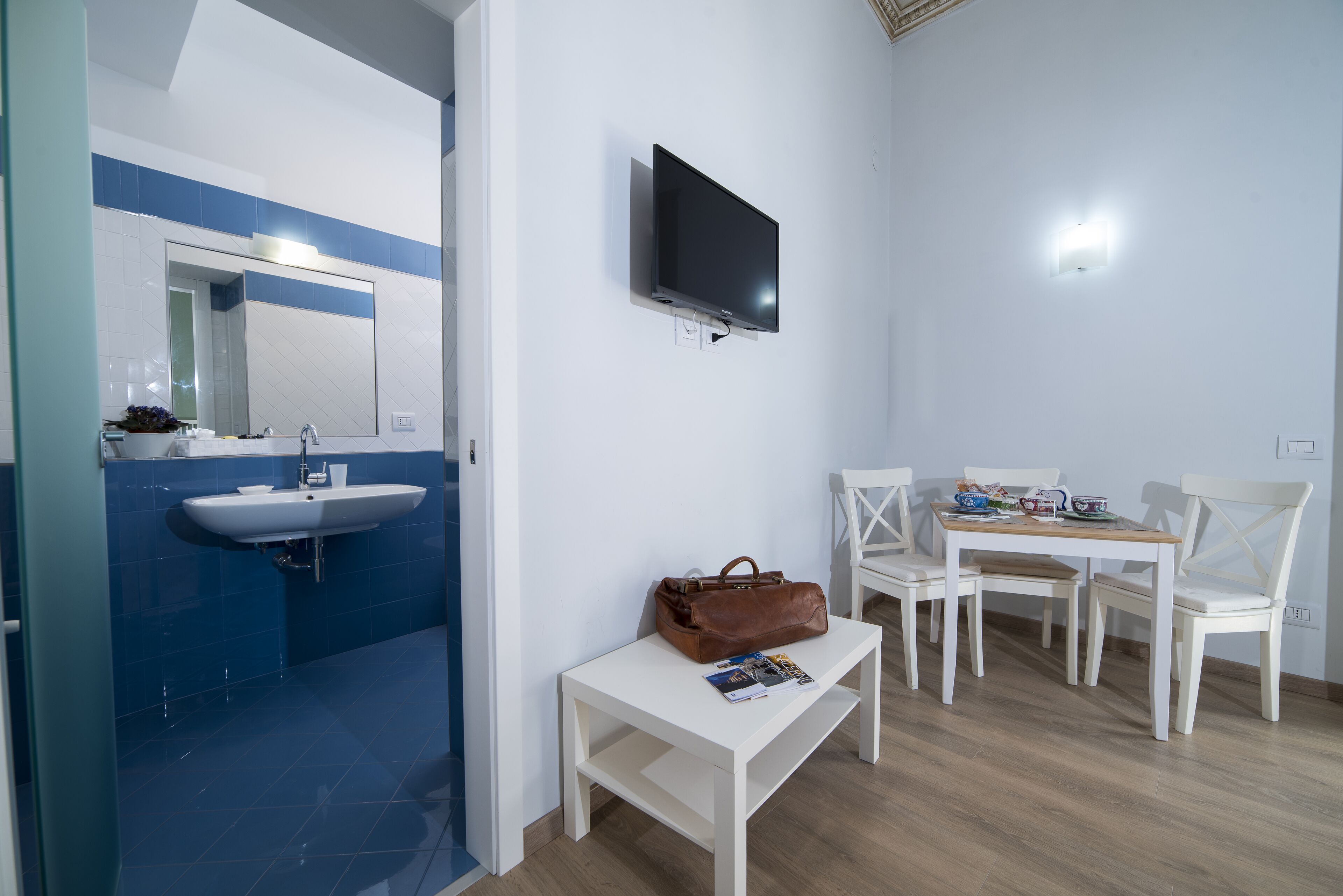 Une salle de bain moderne équipée d’un lavabo, d’un miroir et d’un téléviseur à écran plat fixé au mur.
