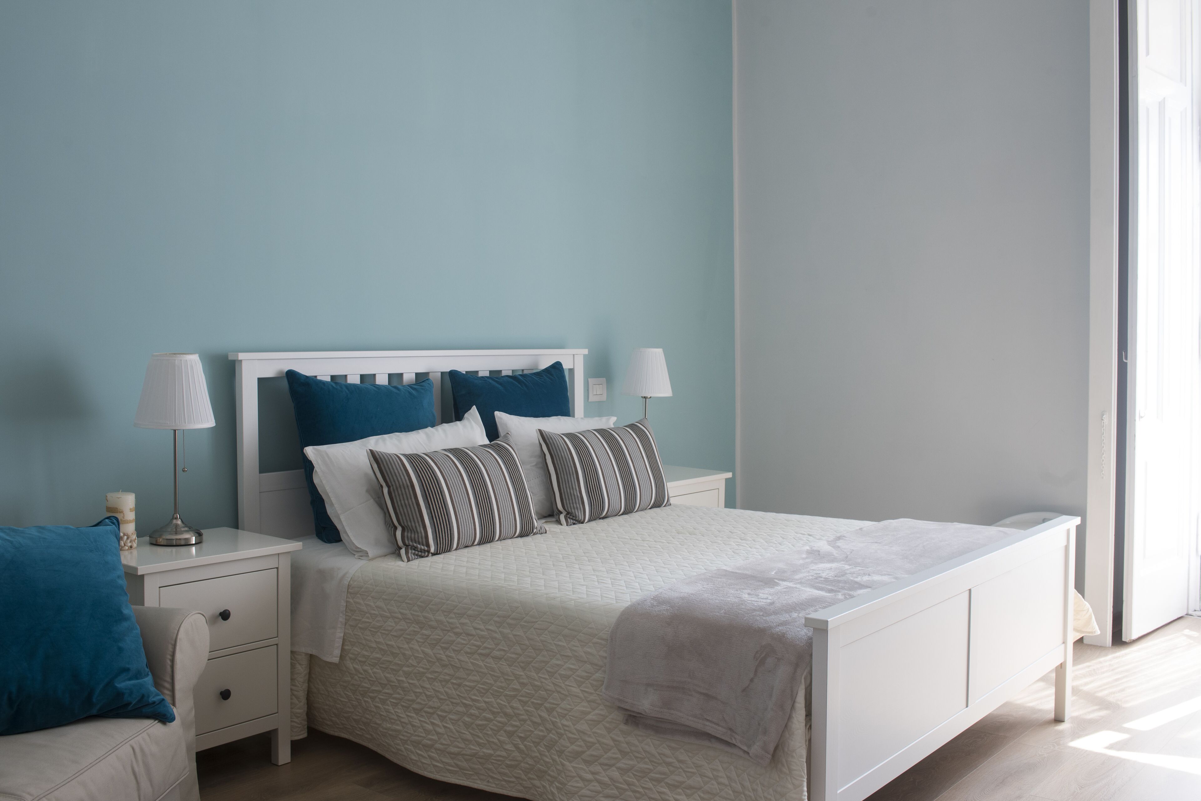 A bedroom with a bed, nightstands, and lamps.