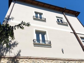 Ein mehrstöckiges Gebäude mit Balkonen und einer Steinsockel.
