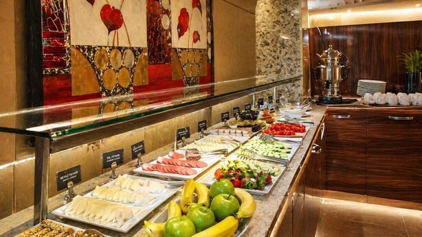 Un bufé con diversas opciones de comida, como frutas, verduras y carnes.