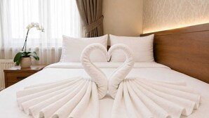 Una cama con dos toallas dispuestas en forma de cisnes.