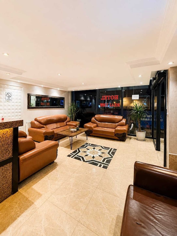 A modern living room with leather sofas, a coffee table, and a patterned rug.