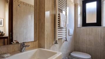 Ein Badezimmer mit einem großen Waschbecken, zwei Toiletten und einem Fenster.