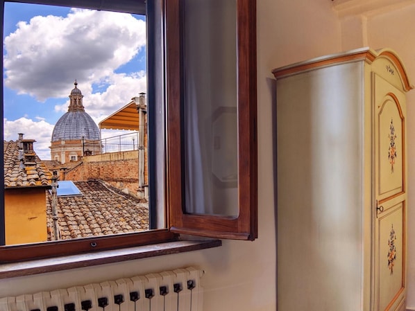A window with a view of a historic building with a dome and tiled roofs. - B&B Dei Rossi (Siena)