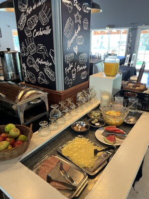 A buffet setup with various food items and a chalkboard menu.