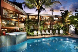 A pool area with lounge chairs and a tiled pool. - Pousada Terra Juquehy (São Sebastião)