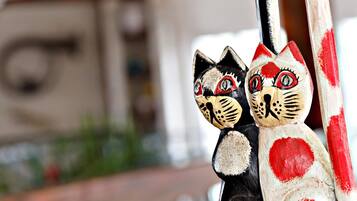 Two painted cat figures leaning against a wall.