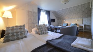 Una habitación de hotel con cama, escritorio, silla y televisión.