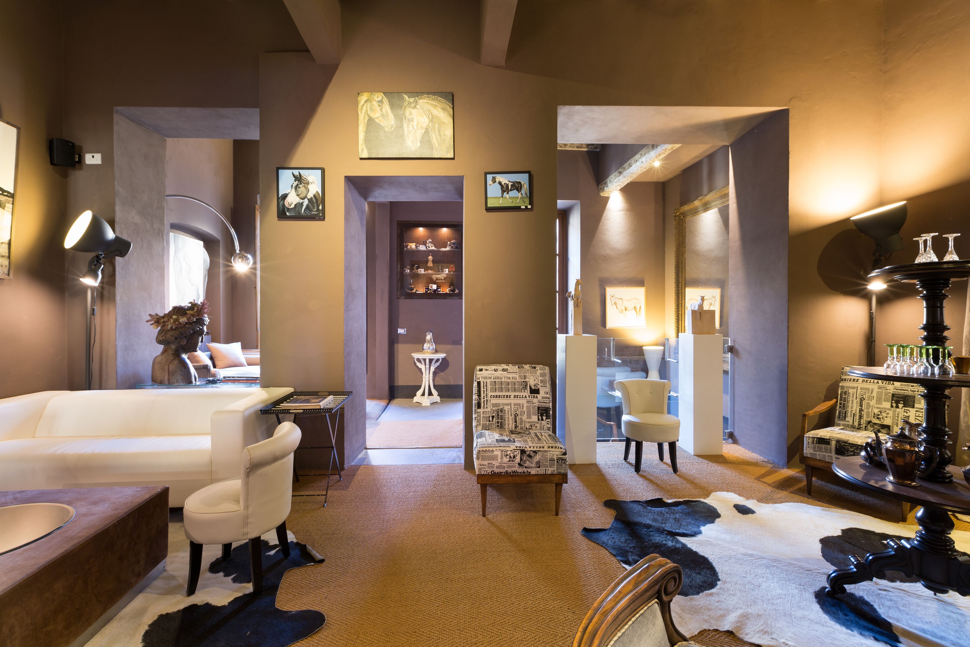 A modern interior with a sofa, armchairs, a rug, and a decorative table.
