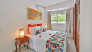 A bedroom with a bed, a nightstand, a window with curtains, and a painting on the wall. - Pipa Centro Residence (Tibau do Sul)
