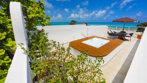 A rooftop terrace with a hot tub, outdoor seating, and a view of the ocean. - Pipa Centro Residence (Tibau do Sul)