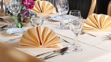 A table set for a formal dining experience with folded napkins, clear glassware, and silverware.