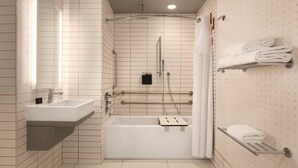 Un baño moderno con un lavamanos blanco, una bañera y una ducha. Hay toalleros en la pared y un espejo sobre el lavamanos.