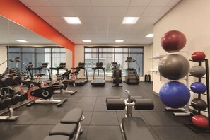 Et fitnessrum med konditionsmaskiner, vægte og træningsbolde.