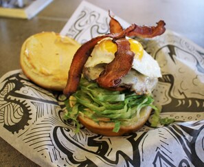 Un sándwich de tocino, huevo y lechuga sobre un papel estampado.