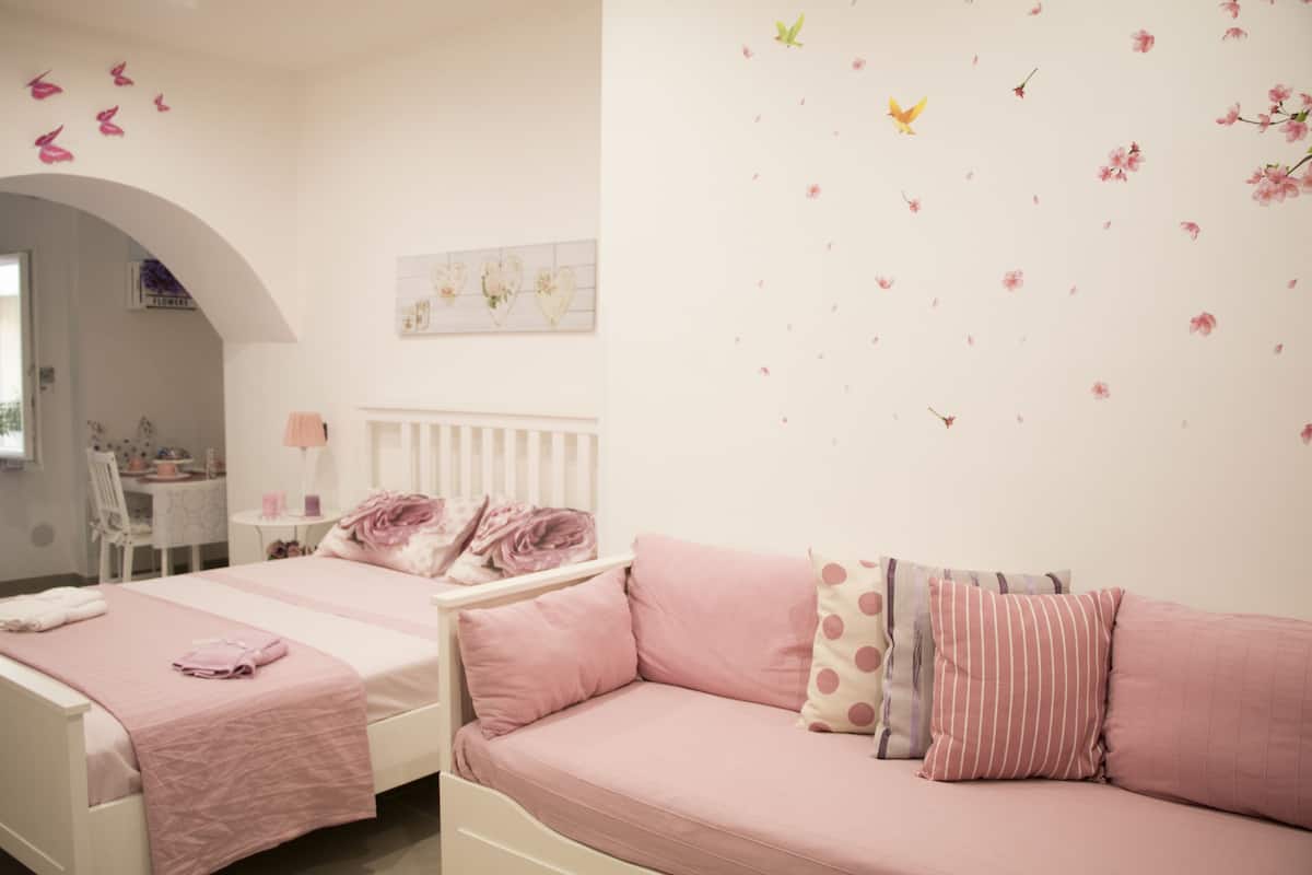 Un dormitorio con cama, sofá y escritorio.