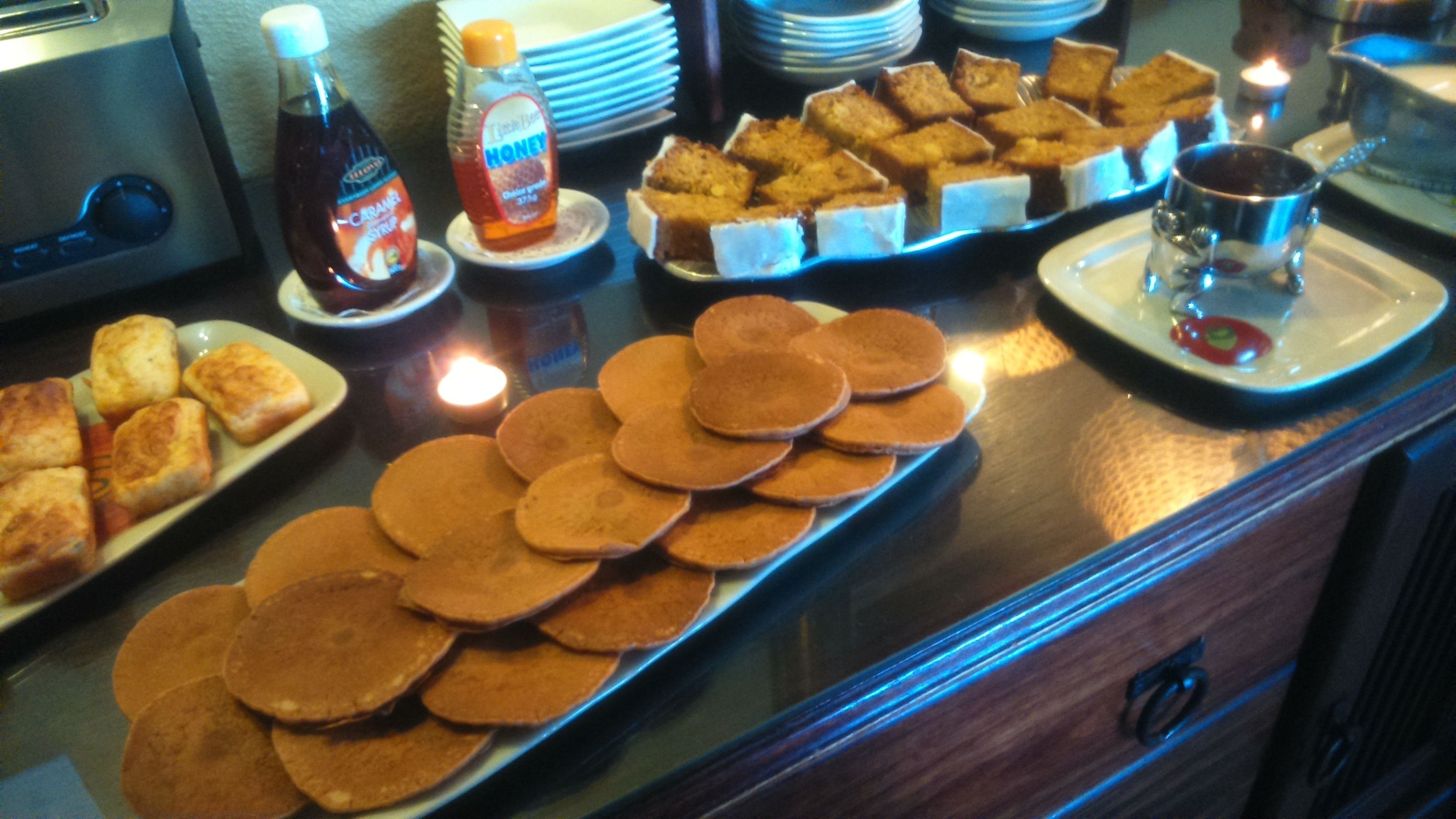 Buffet com panquecas, torradas e diversos doces.