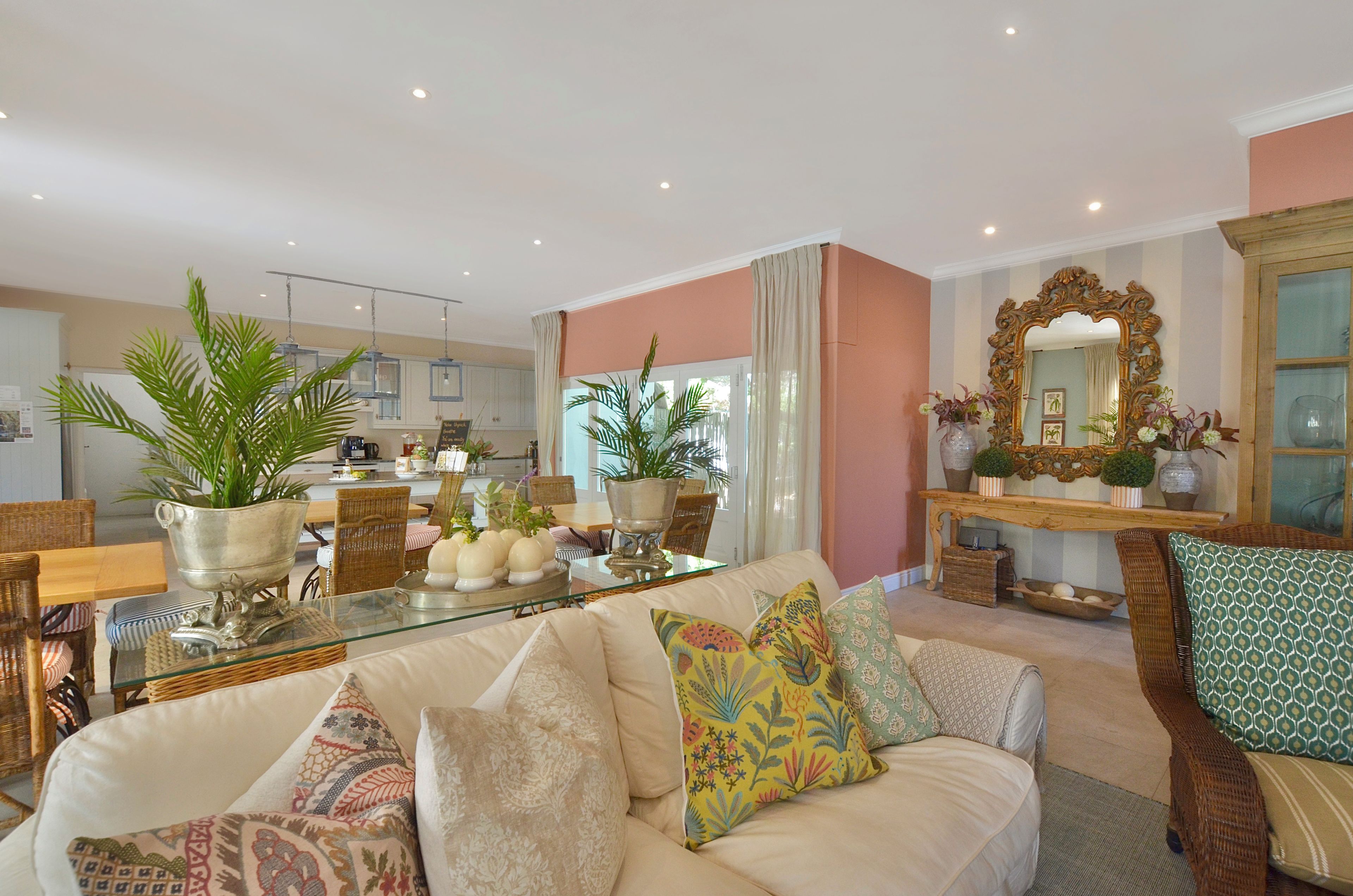 A living room with a sofa, cushions, a coffee table, and a dining area with chairs and a table.