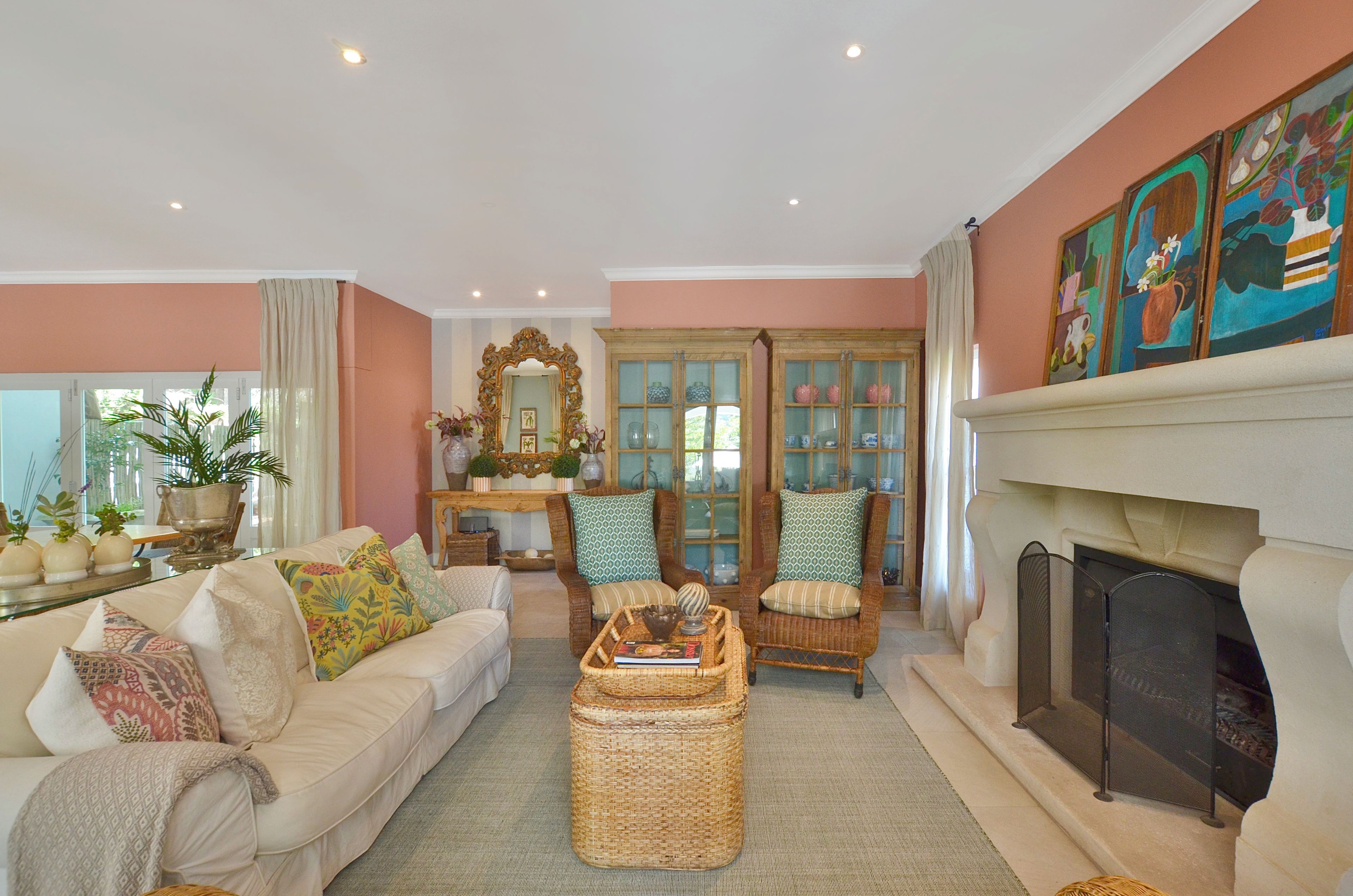 A living room with a fireplace, a sofa set, a coffee table, and a decorative mirror.