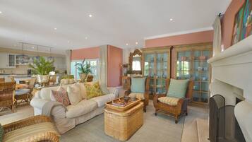 A spacious living room with a sofa, chairs, a coffee table, and a fireplace.