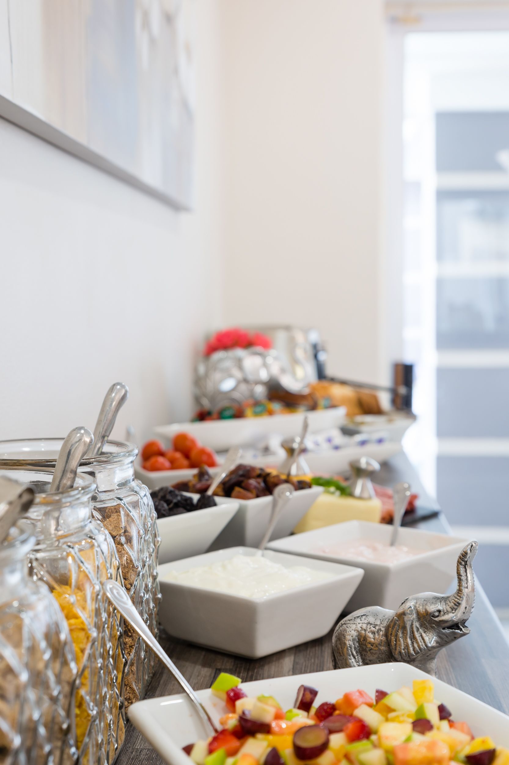 Una mesa de buffet con diversos alimentos y utensilios de servir.