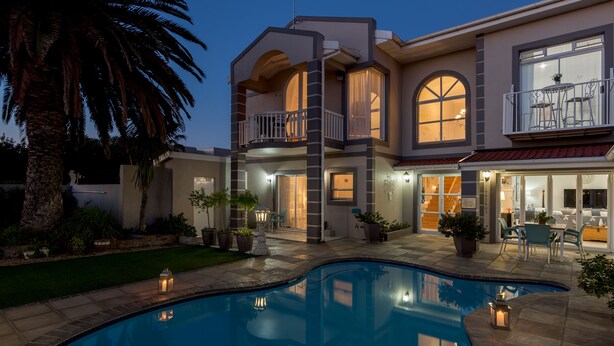 A two-story house with a swimming pool, outdoor seating, and a balcony. - Atlantic Beach Villa (Cape Town)
