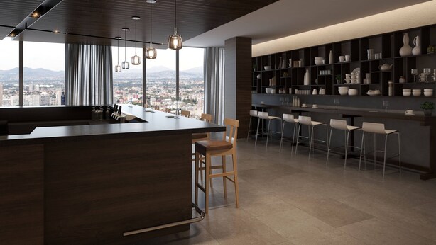 A modern kitchen with a large island, bar seating, and a view of the city.