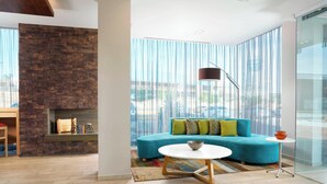 A modern living room with a blue sofa, a white coffee table, and a brick fireplace.