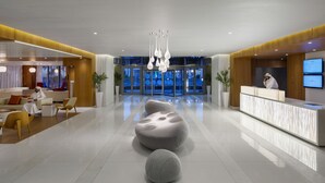 A modern hotel lobby with a reception desk, seating areas, and a large chandelier. - Novotel Jeddah Tahlia (Jeddah)