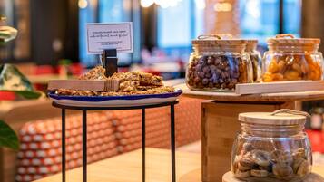 Uma mesa de buffet com granola, nozes e frutas secas.