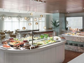 A buffet with various food items and a seating area with chairs and tables. - Novotel Jeddah Tahlia (Jeddah)