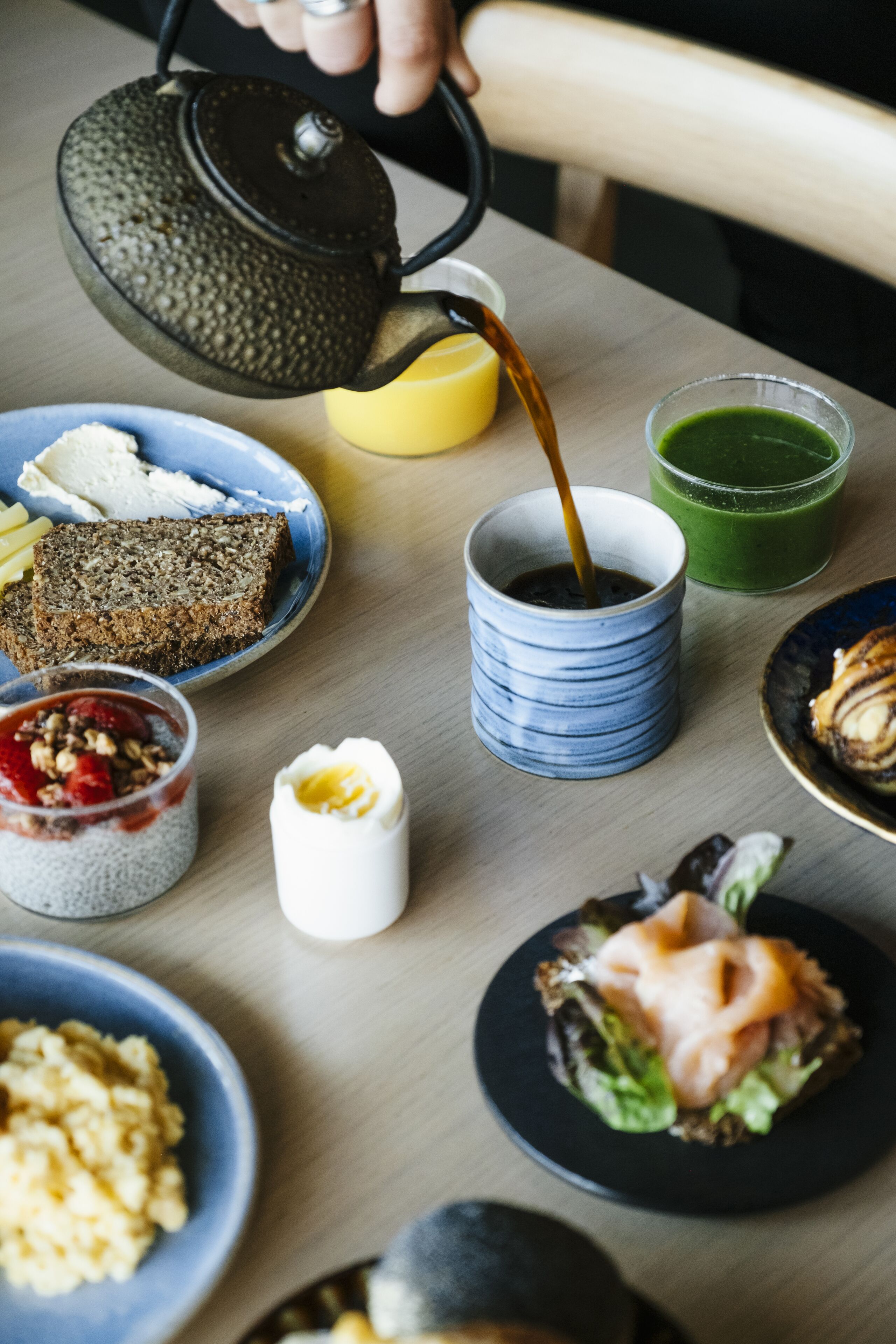 Een tafel met diverse ontbijtartikelen, zoals toast, ontbijtgranen en een kop koffie.
