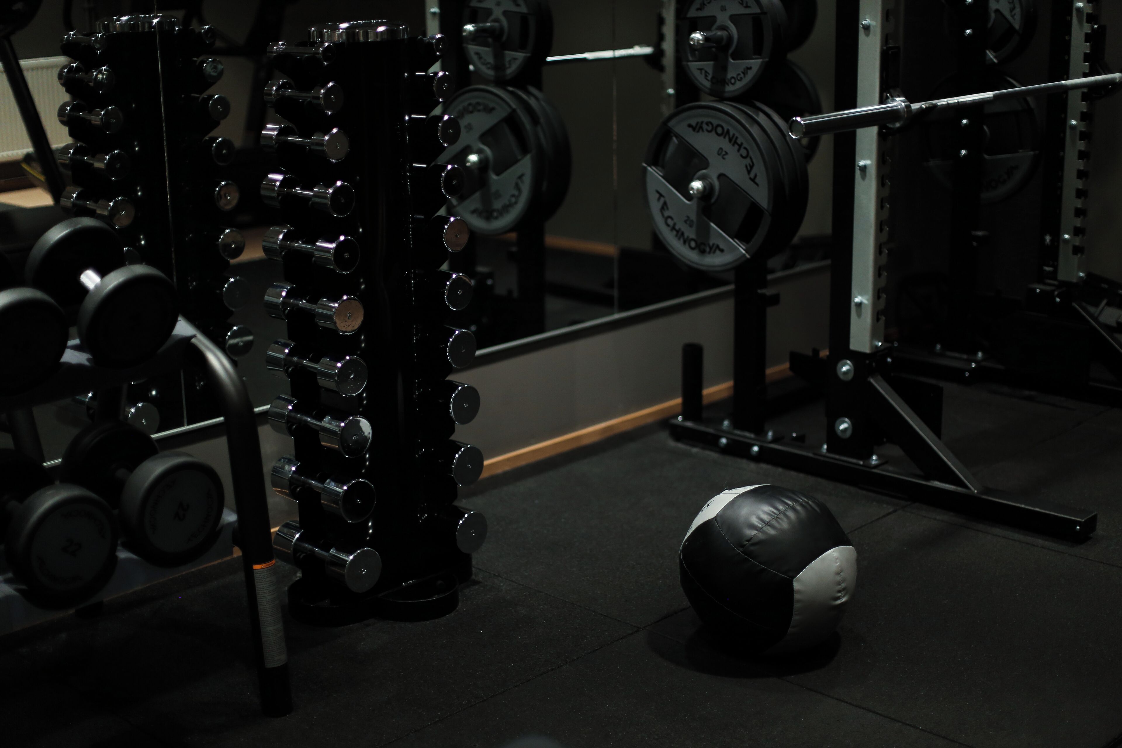A gym with weightlifting equipment, including dumbbells and barbells.