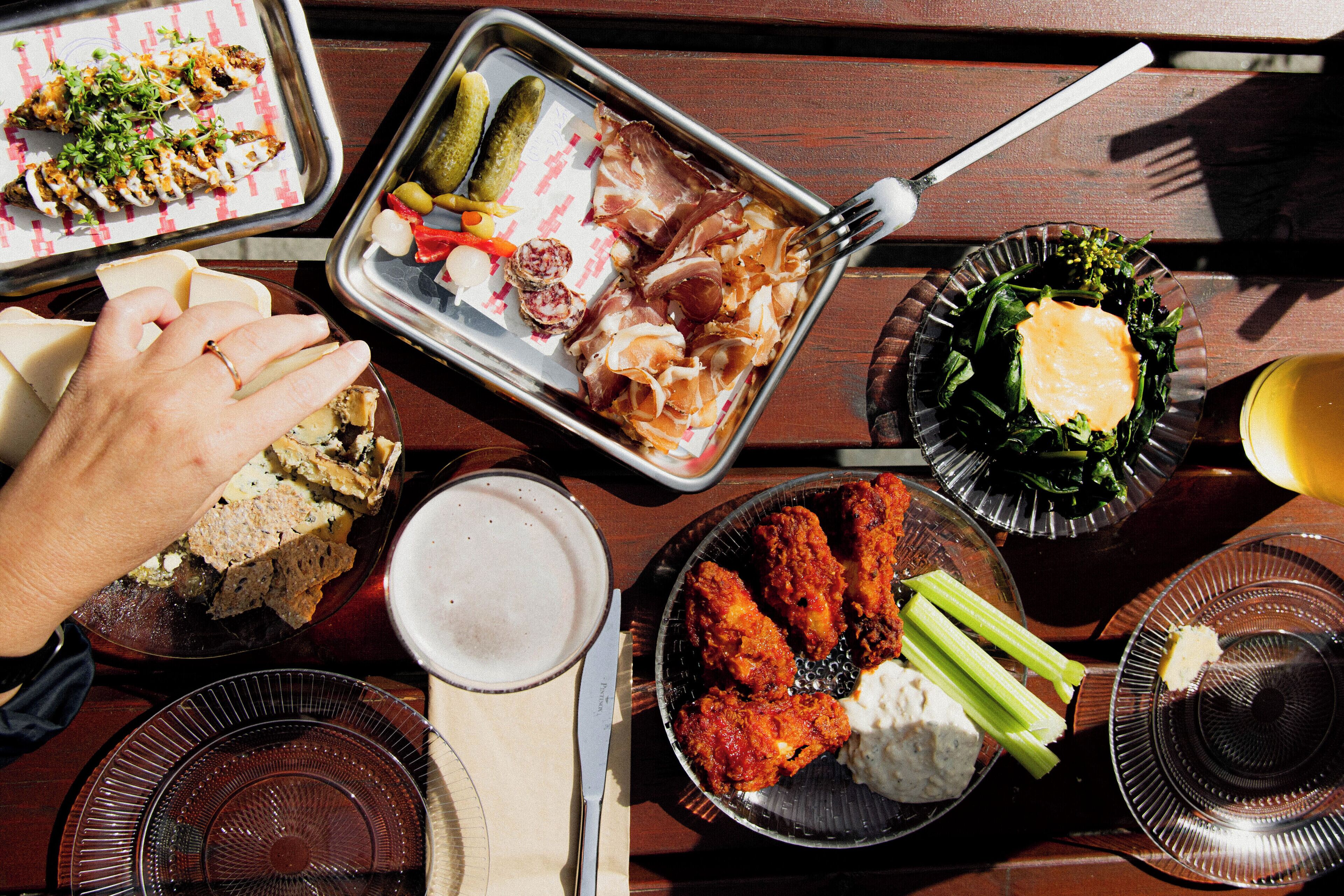 A table with various dishes including bread, meat, vegetables, and a drink.