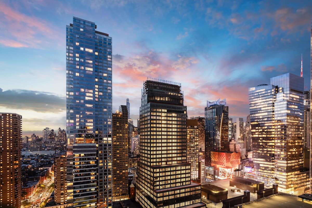 Paisagem urbana com edifícios altos, incluindo um arranha-céu imponente com design singular.