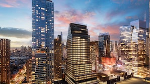 Paisagem urbana com edifícios altos, incluindo um arranha-céu imponente com design singular.
