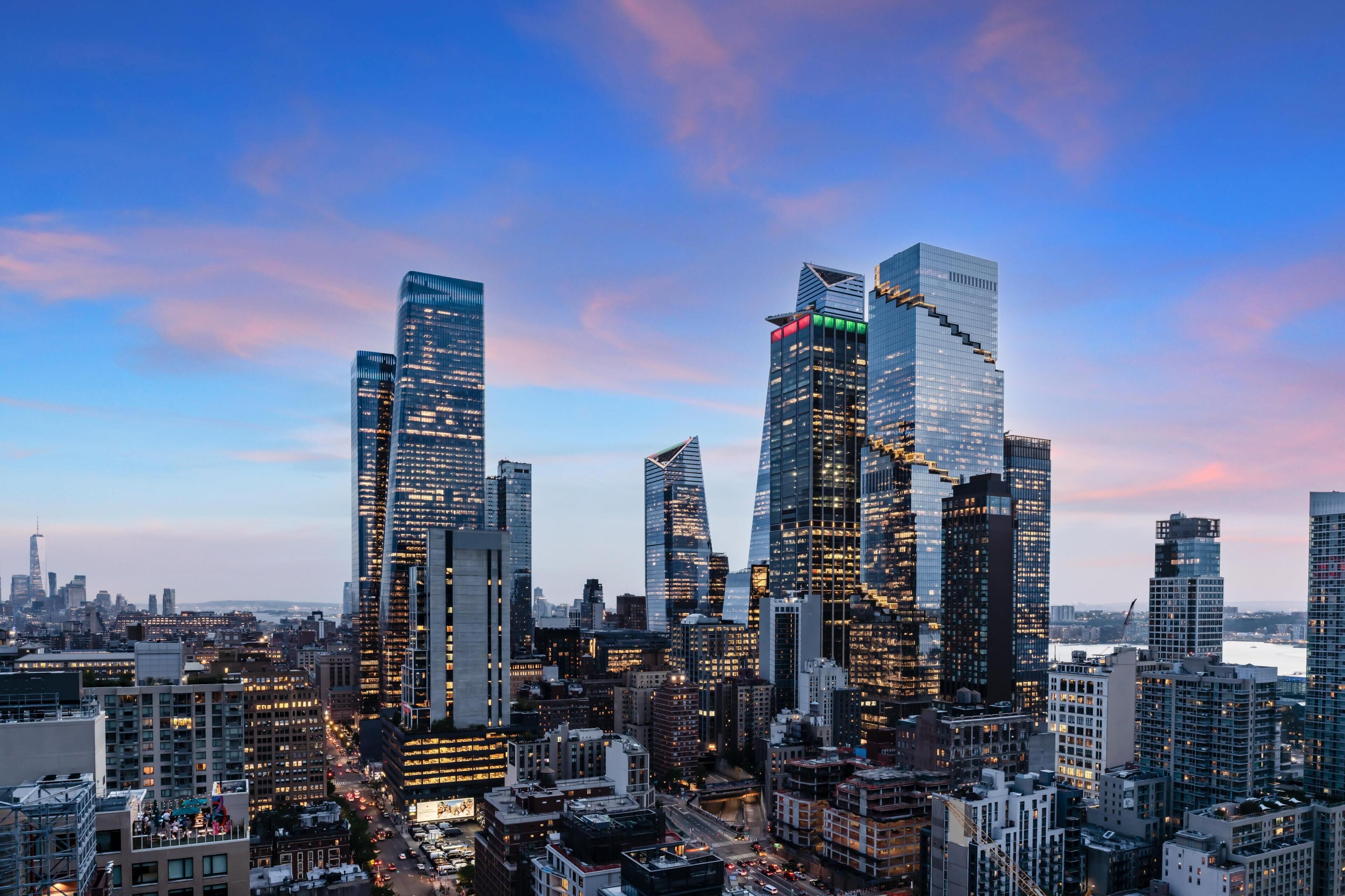 A cityscape with modern skyscrapers, a river, and a clear sky.