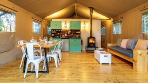 Un intérieur de chalet chaleureux comprenant un coin repas, une cuisine et une cheminée.